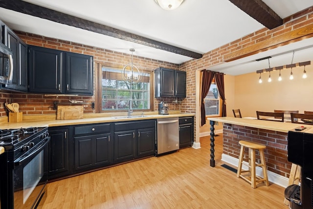 122 E Sherman St, Bartlett, IL 60103 - kitchen featuring stainless steel dishwasher, black gas stove, a sink, light wood-type flooring, and light countertops