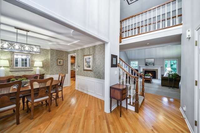 970 Brigham Way, Geneva, IL 60134 - dining space with wood finished floors, a warm lit fireplace, a wainscoted wall, wallpapered walls, and crown molding