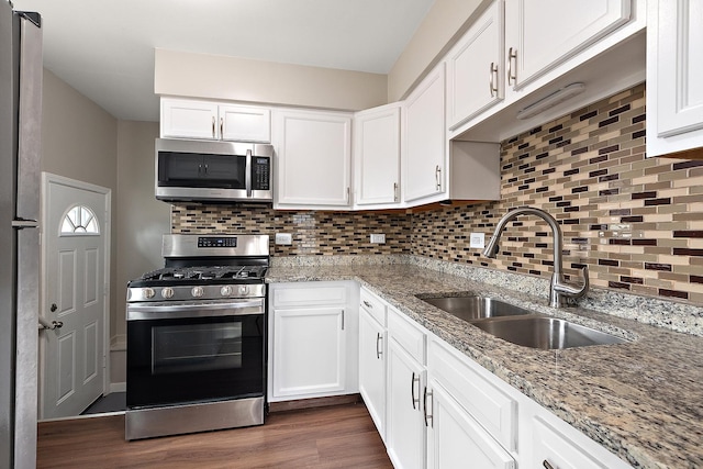 1521 N Wolf Rd, Berkeley, IL 60163 - kitchen featuring appliances with stainless steel finishes, a sink, dark wood-type flooring, white cabinets, and tasteful backsplash