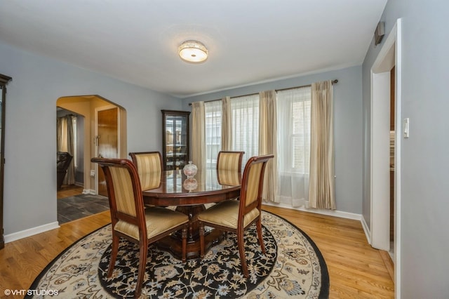 2017 N New England Ave, Chicago, IL 60707 - dining room with arched walkways, light wood-type flooring, and baseboards