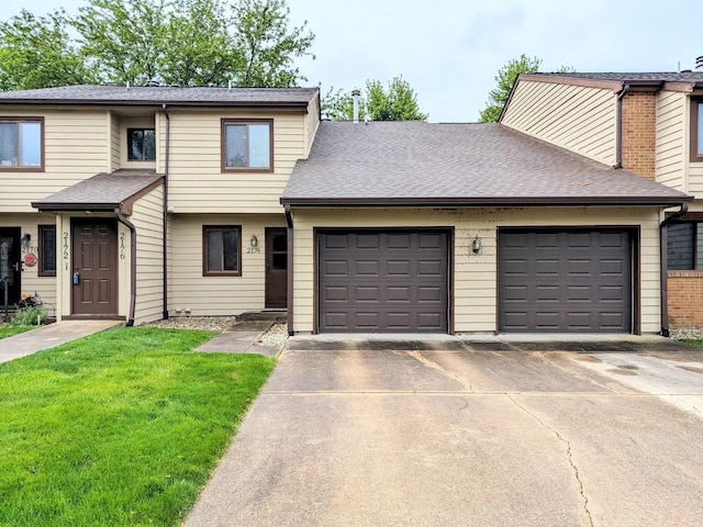 2176 Harbortown Cir Unit 2176, Champaign, IL 61821 - townhome / multi-family property with a garage, concrete driveway, roof with shingles, and a front lawn