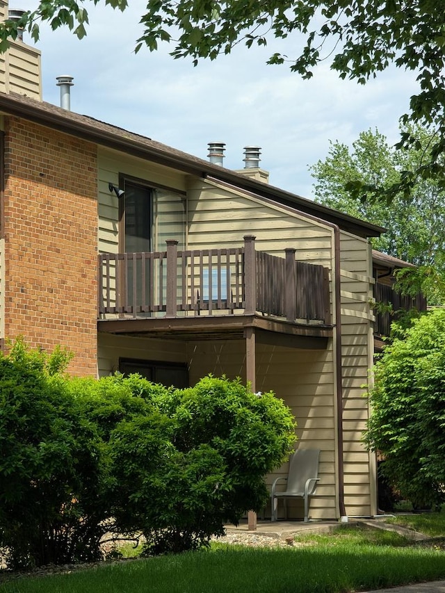 2176 Harbortown Cir Unit 2176, Champaign, IL 61821 - rear view of property featuring a balcony, a chimney, and brick siding