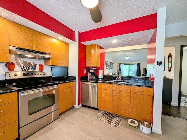 2176 Harbortown Cir Unit 2176, Champaign, IL 61821 - kitchen with appliances with stainless steel finishes, under cabinet range hood, a ceiling fan, light wood-style floors, and dark countertops