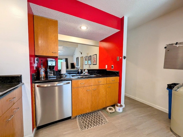 2176 Harbortown Cir Unit 2176, Champaign, IL 61821 - kitchen featuring dishwasher, a sink, light wood-style flooring, a textured ceiling, and dark countertops