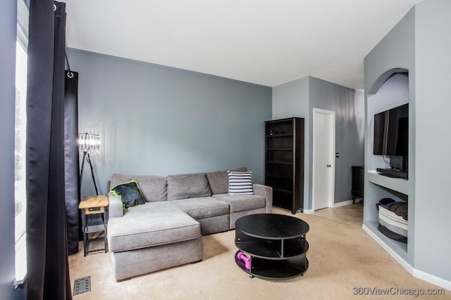 carpeted living room with baseboards