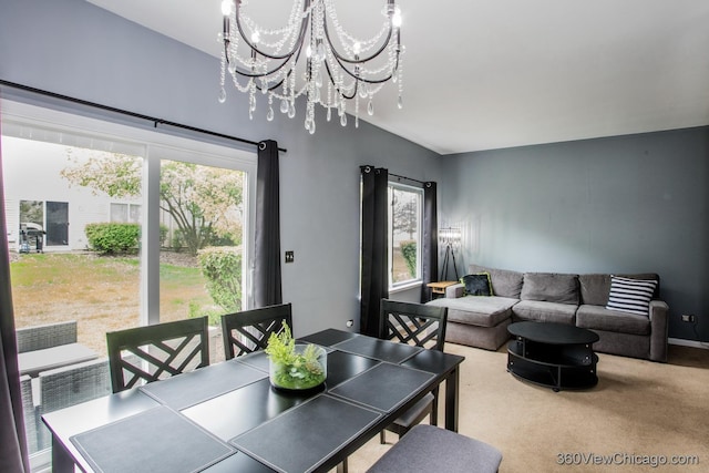 dining space featuring healthy amount of natural light, a chandelier, and carpet floors