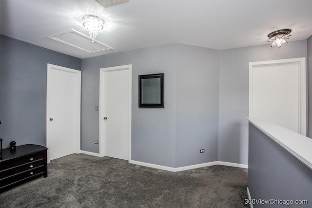 unfurnished bedroom featuring attic access, carpet flooring, and baseboards
