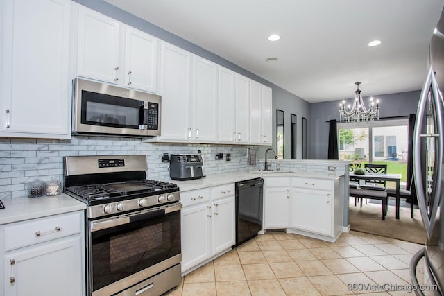 kitchen with appliances with stainless steel finishes, a sink, a chandelier, light countertops, and recessed lighting