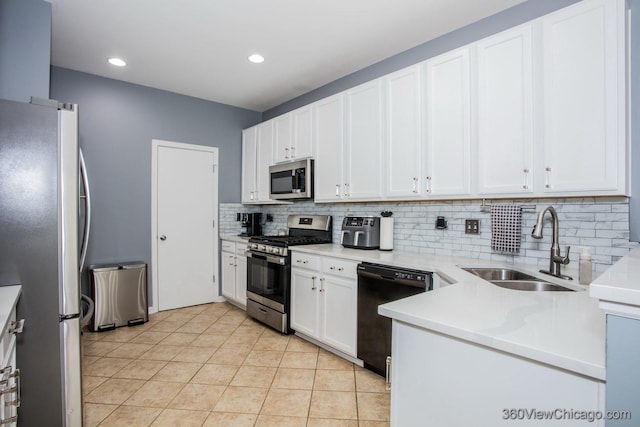 kitchen featuring stainless steel appliances, a sink, tasteful backsplash, white cabinetry, and light countertops