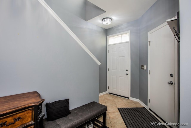 entryway featuring light tile patterned floors, stairway, and baseboards