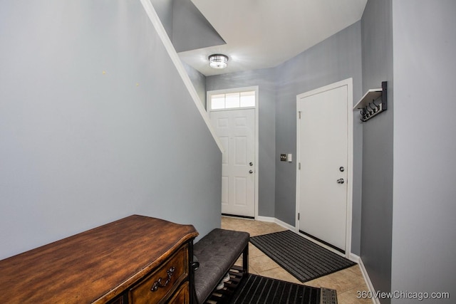 doorway featuring light tile patterned floors and baseboards