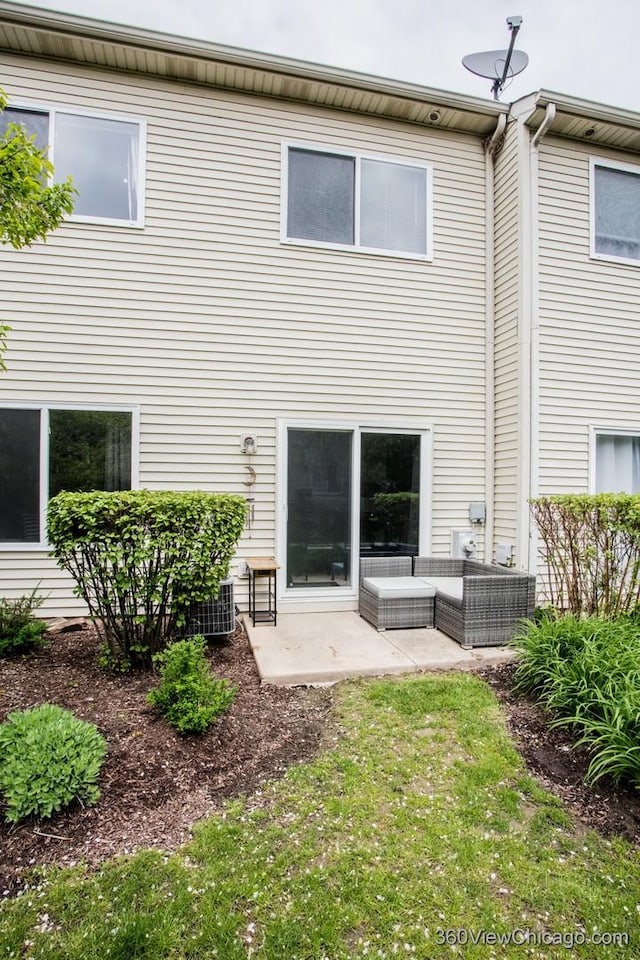 rear view of property with a patio area, an outdoor living space, and cooling unit