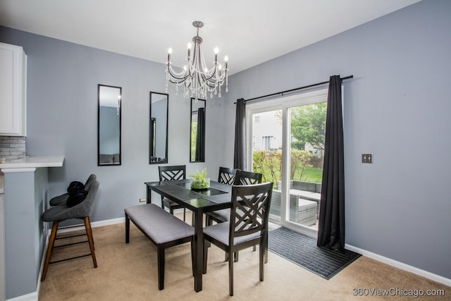 dining space with light carpet, a chandelier, and baseboards