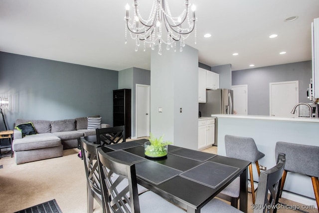 dining area with a chandelier, recessed lighting, and light colored carpet