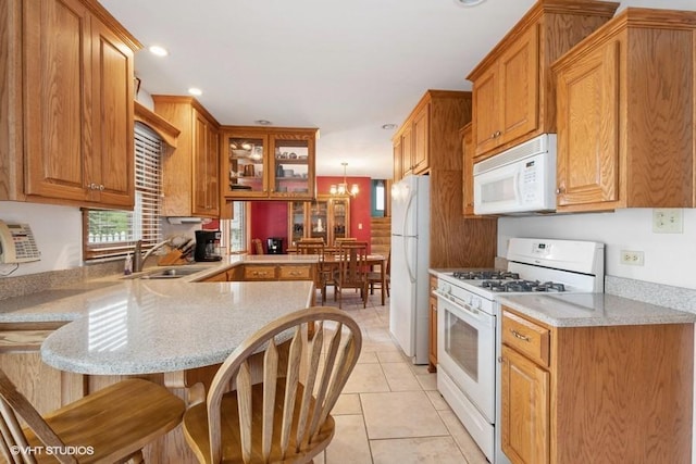 18457 Virginia Ln, Mokena, IL 60448 - kitchen featuring white appliances, a sink, a peninsula, a breakfast bar area, and glass insert cabinets