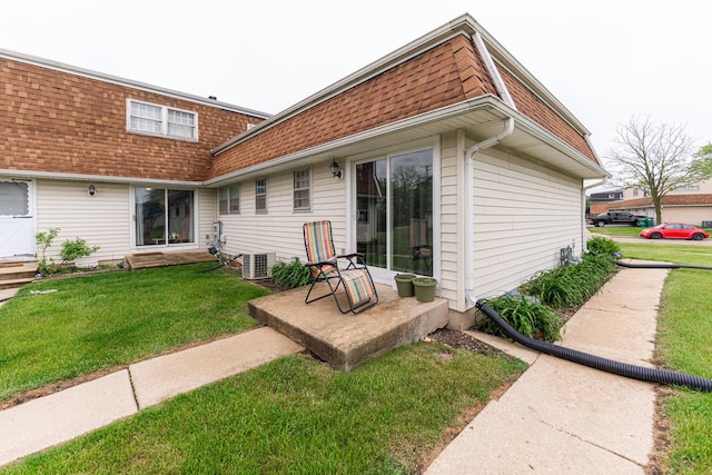 1409 E Stonehenge Dr Unit 1409, Sycamore, IL 60178 - rear view of house with roof with shingles, a yard, mansard roof, and central air condition unit