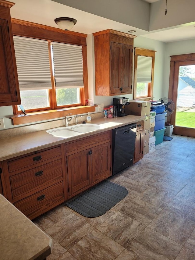 442 High St, Buda, IL 61314 - kitchen with black dishwasher, a sink, light countertops, and brown cabinetry
