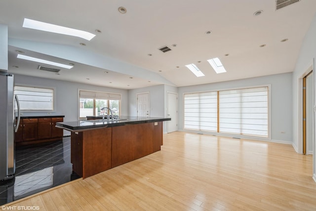 489 Good Ave, Des Plaines, IL 60016 - kitchen with a skylight, vaulted ceiling, a sink, freestanding refrigerator, and light wood finished floors