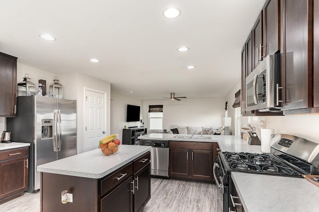 3917 Kristen Ct, Plano, IL 60545 - kitchen with appliances with stainless steel finishes, open floor plan, dark brown cabinets, light countertops, and light wood-style flooring