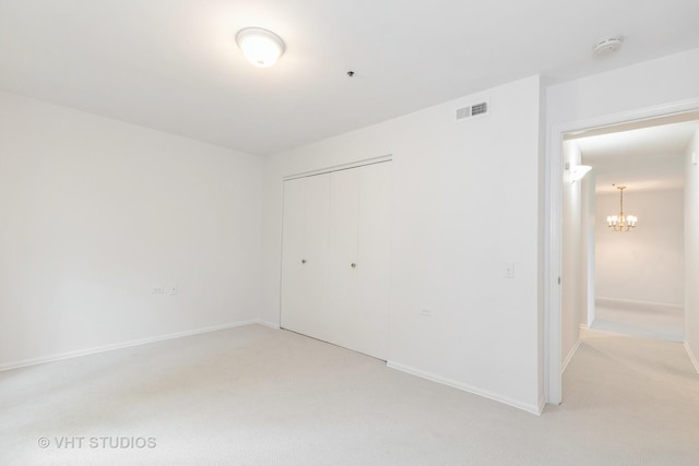 800 Ridge Rd Unit 108, Wilmette, IL 60091 - unfurnished bedroom featuring a chandelier, light carpet, a closet, and baseboards