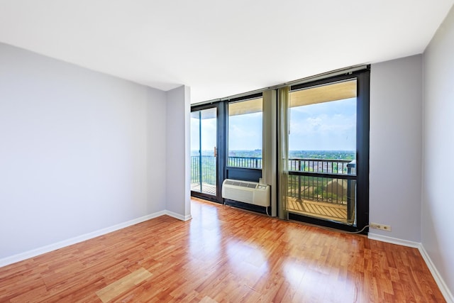 2901 S Michigan Ave Unit 1706, Chicago, IL 60616 - unfurnished room with wood finished floors, baseboards, floor to ceiling windows, and a wall mounted air conditioner
