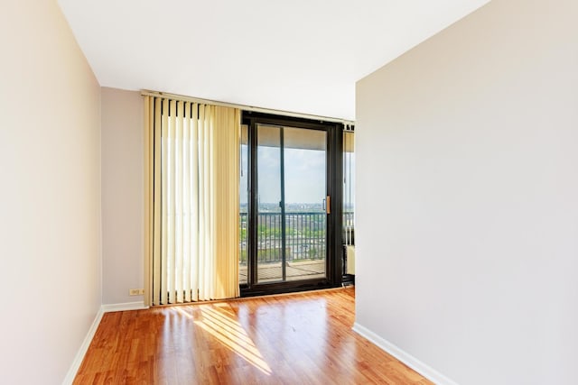 2901 S Michigan Ave Unit 1706, Chicago, IL 60616 - unfurnished room featuring floor to ceiling windows, wood finished floors, and baseboards