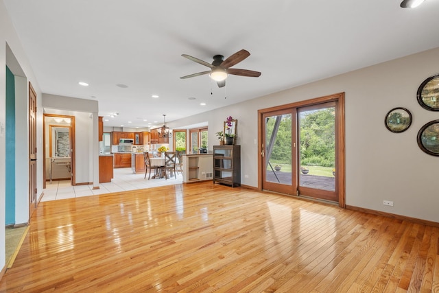 60 Romiga Ln, Palos Park, IL 60464 - unfurnished living room with light wood-style flooring, baseboards, a ceiling fan, a chandelier, and recessed lighting