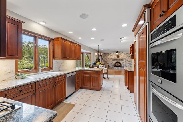 60 Romiga Ln, Palos Park, IL 60464 - kitchen with a sink, appliances with stainless steel finishes, a brick fireplace, a peninsula, and tasteful backsplash