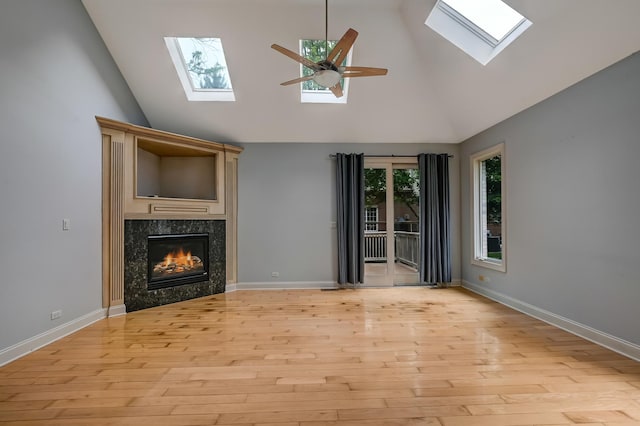 740 Fairmont Ct, Westmont, IL 60559 - unfurnished living room featuring a skylight, a high end fireplace, high vaulted ceiling, light wood-style flooring, and ceiling fan