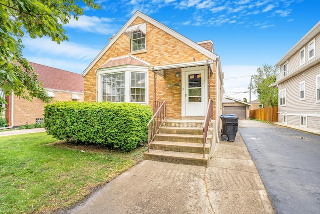 3113 N Osceola Ave, Chicago, IL 60707 - view of front facade with brick siding, an outdoor structure, a garage, and a front yard