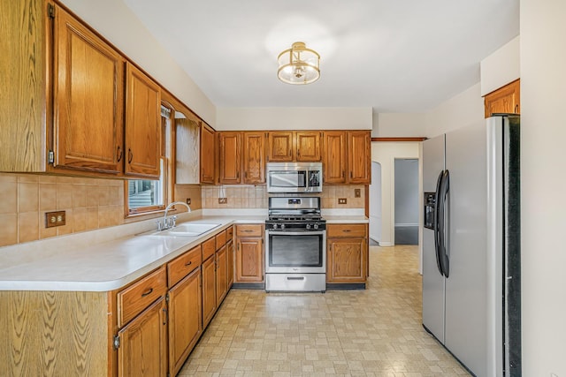 3113 N Osceola Ave, Chicago, IL 60707 - kitchen featuring stainless steel appliances, a sink, light countertops, and brown cabinets