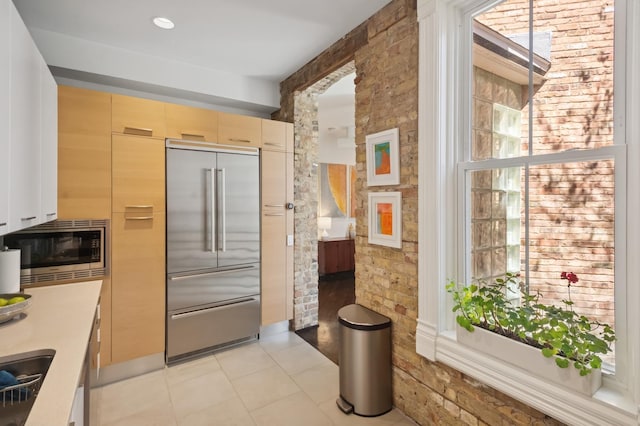 832 W Wolfram St, Chicago, IL 60657 - kitchen featuring built in appliances, light tile patterned flooring, and light countertops