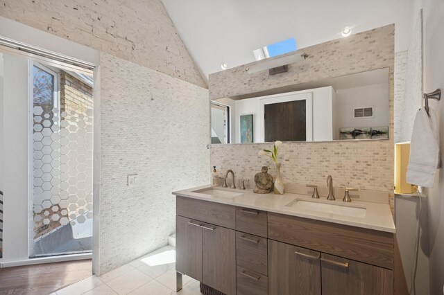 832 W Wolfram St, Chicago, IL 60657 - full bath featuring double vanity, decorative backsplash, high vaulted ceiling, and tile patterned floors