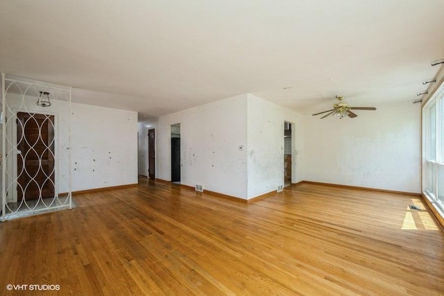 9011 Menard Ave, Morton Grove, IL 60053 - unfurnished living room with light wood-style floors, a ceiling fan, and baseboards