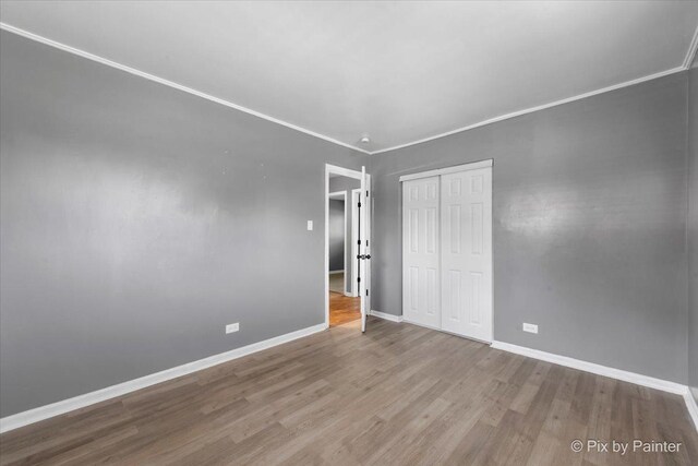2756 Lancaster Dr, Markham, IL 60428 - unfurnished bedroom with wood finished floors, baseboards, a closet, and crown molding