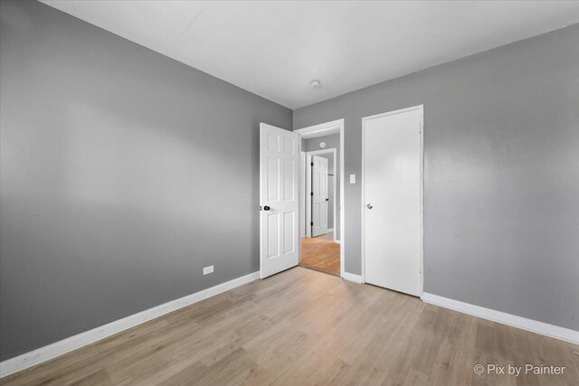 2756 Lancaster Dr, Markham, IL 60428 - unfurnished bedroom with wood finished floors, baseboards, and a closet