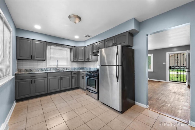 2756 Lancaster Dr, Markham, IL 60428 - kitchen featuring stainless steel appliances, gray cabinets, a sink, under cabinet range hood, and backsplash