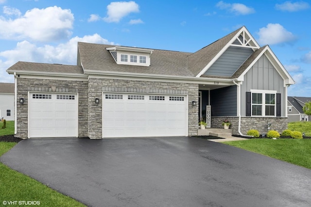 319 Carole St, Sugar Grove, IL 60554 - view of front facade with stone siding, an attached garage, asphalt driveway, and board and batten siding