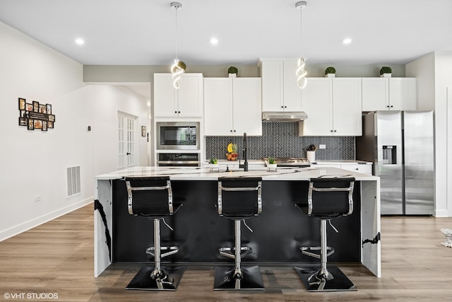 319 Carole St, Sugar Grove, IL 60554 - kitchen featuring stainless steel appliances, a center island with sink, backsplash, light countertops, and recessed lighting