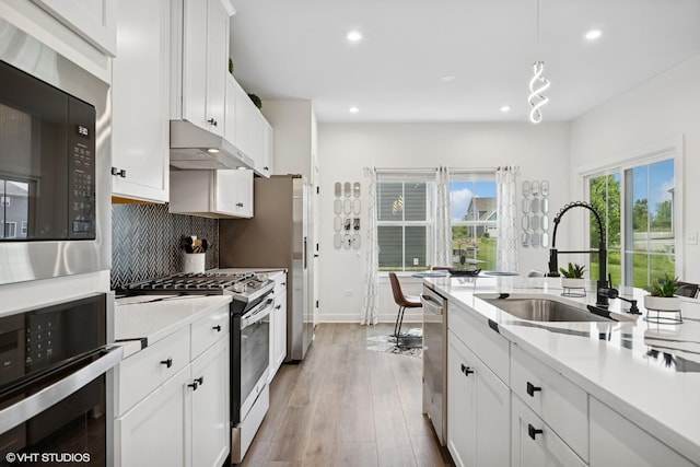 319 Carole St, Sugar Grove, IL 60554 - kitchen featuring stainless steel appliances, a sink, under cabinet range hood, recessed lighting, and white cabinetry