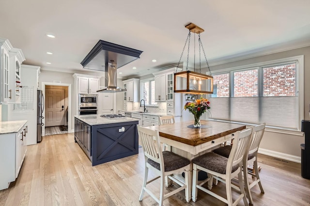 349 Home Ave, Itasca, IL 60143 - kitchen featuring island exhaust hood, appliances with stainless steel finishes, a sink, ornamental molding, and white cabinetry