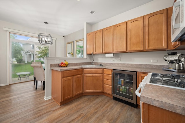 1481 Cambria Dr Unit 1, Dekalb, IL 60115 - kitchen featuring wine cooler, a sink, white microwave, a peninsula, and light wood-style flooring