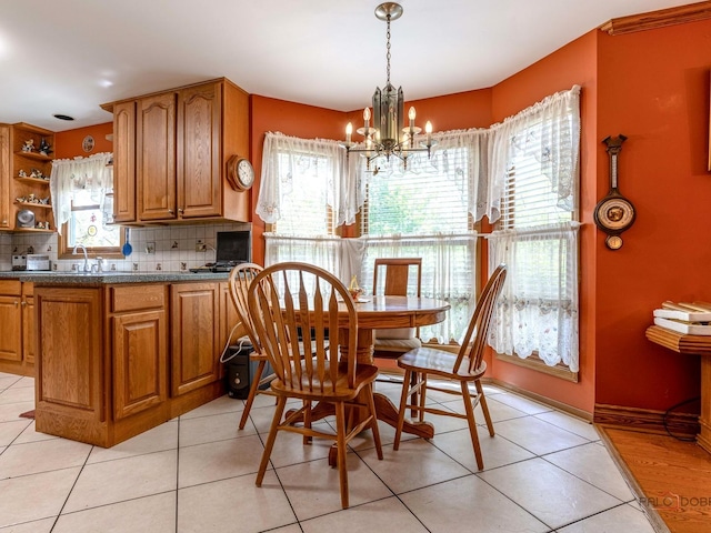 1010 Hampshire Ln, Elgin, IL 60120 - dining area with a chandelier, light tile patterned flooring, and baseboards