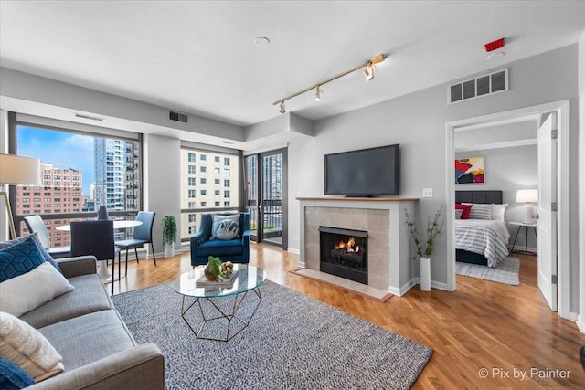 1212 N Wells St Unit 1403, Chicago, IL 60610 - living room with healthy amount of natural light, wood finished floors, a tile fireplace, and baseboards