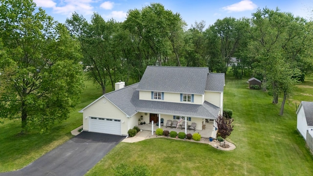 279 N Division St, Braidwood, IL 60408 - view of front facade featuring driveway, an attached garage, a porch, a chimney, and a front lawn
