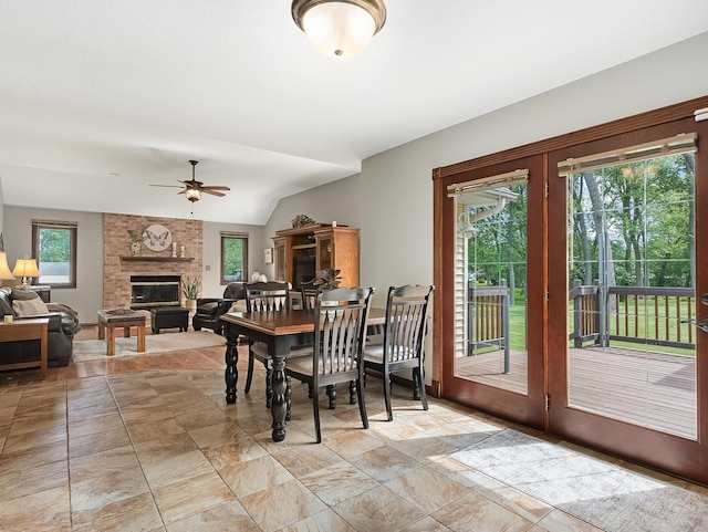 279 N Division St, Braidwood, IL 60408 - dining space featuring a ceiling fan, a fireplace, light stone finish floors, and lofted ceiling