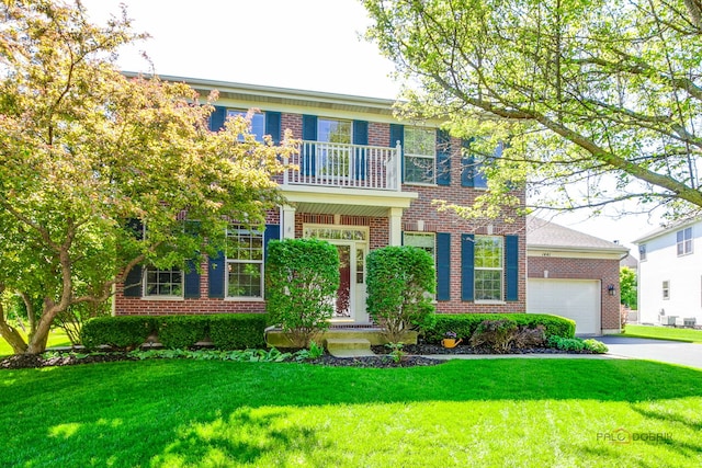 1441 Sutton Pl, Gurnee, IL 60031 - colonial-style house with brick siding, a balcony, asphalt driveway, and a front yard
