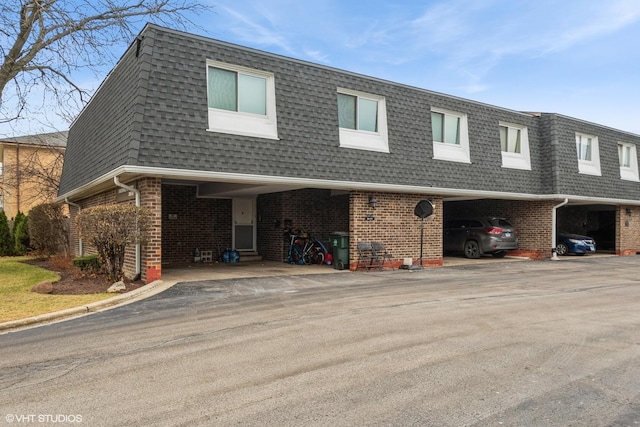 2856 W Touhy Ave Unit C, Chicago, IL 60645 - view of property featuring mansard roof, roof with shingles, and brick siding