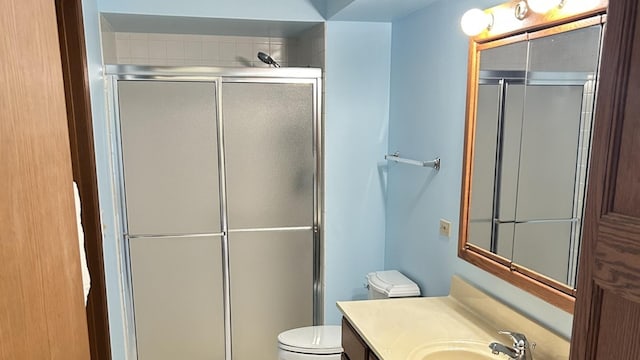 bathroom with toilet, an enclosed shower, and vanity