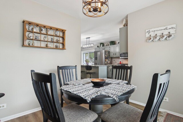 1034 Willoby Ln, Elgin, IL 60120 - dining room with a chandelier, baseboards, and dark wood-type flooring